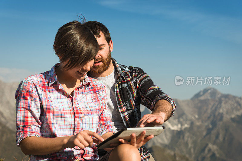 夫妇在山上使用平板电脑