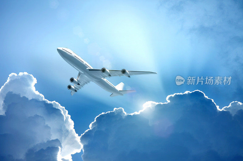 一架白色喷气式飞机带着阳光飞过云层