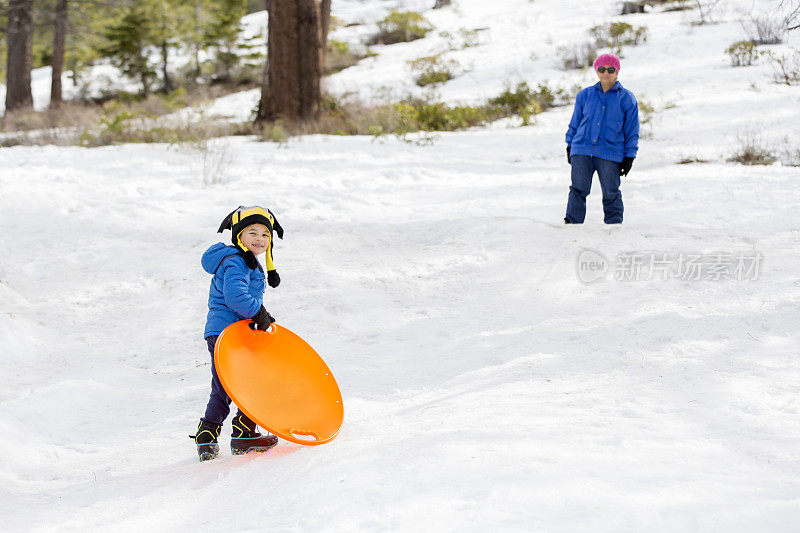 冬天的乐趣:奶奶和孙子玩雪橇