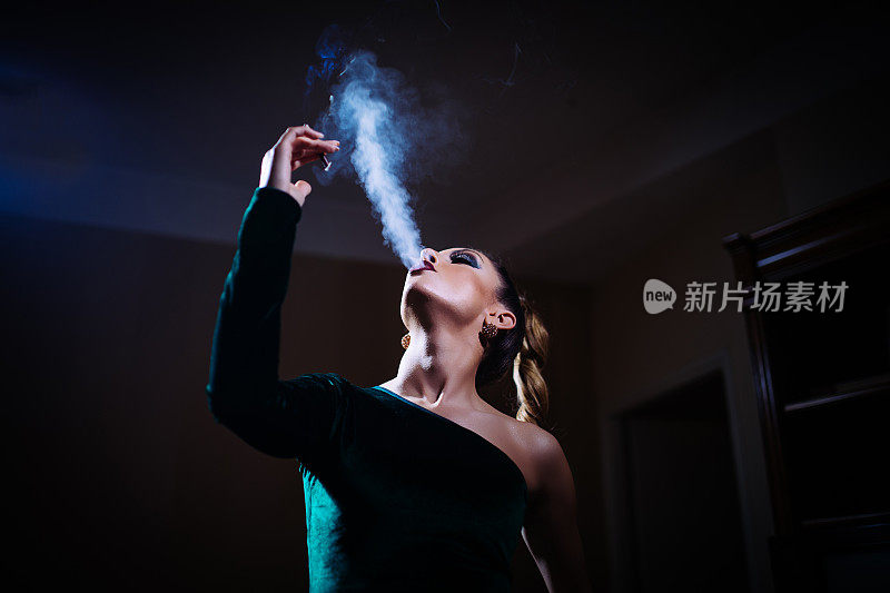 穿着绿色衣服吸烟的女士