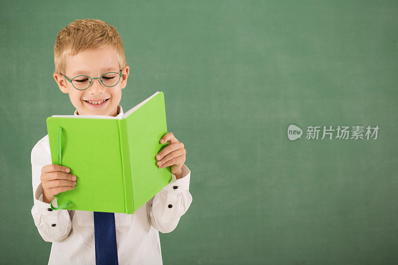 小男孩在黑板前看书