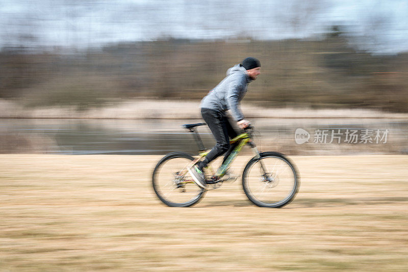 一个寒冷的冬天，年轻的山地自行车手在湖边骑车