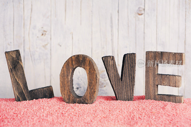 “爱”这个词用木字写在一个乡村的背景上