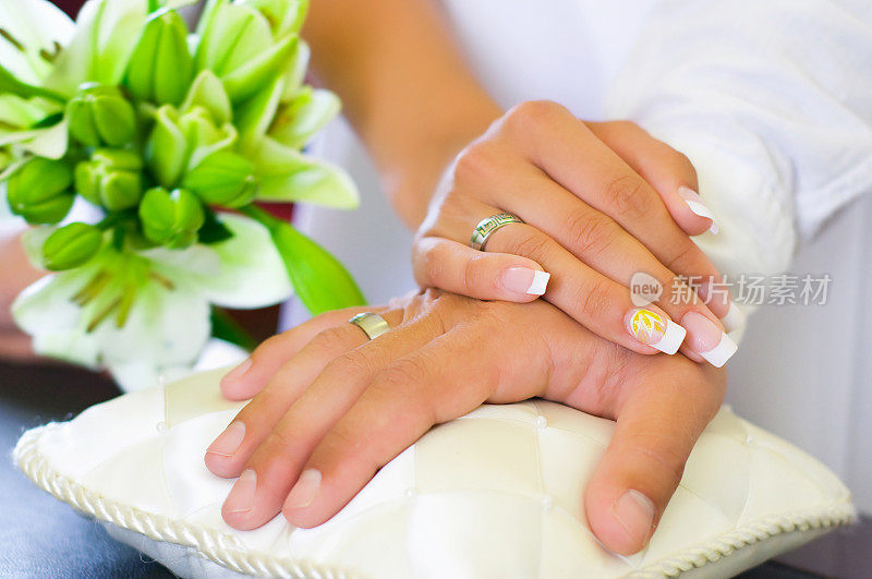 结婚戒指戴在新娘和新郎的手上。