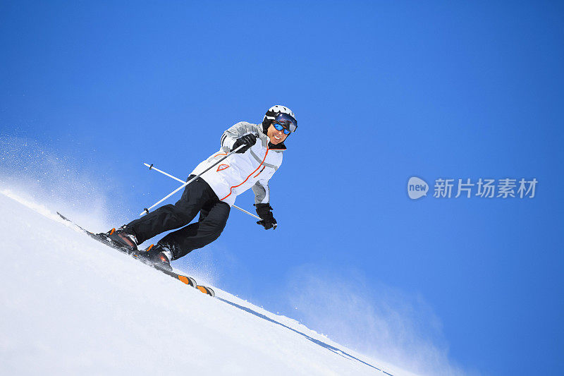 男子滑雪者在阳光明媚的滑雪胜地滑雪冬季运动