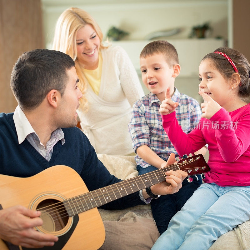 快乐的家庭在家里弹吉他