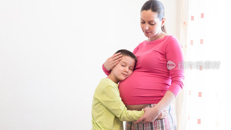 怀孕的母亲拥抱她的儿子