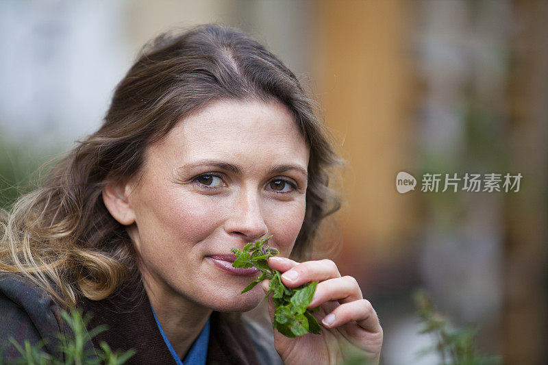 漂亮的年轻女人闻着薄荷味