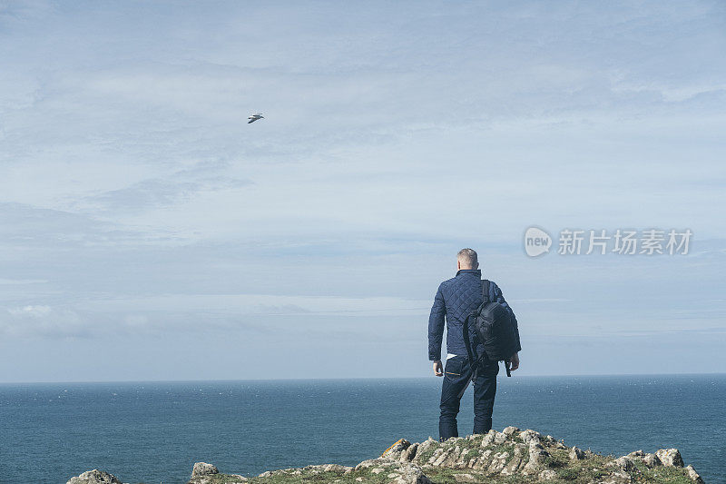 一名男子站在康沃尔金纳斯湾附近的悬崖边缘