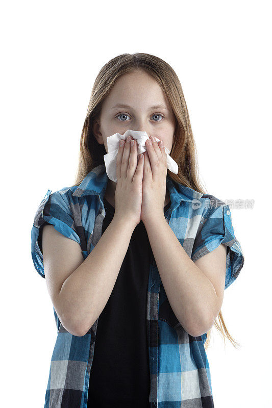 感冒的金发女孩用纸巾擤鼻子