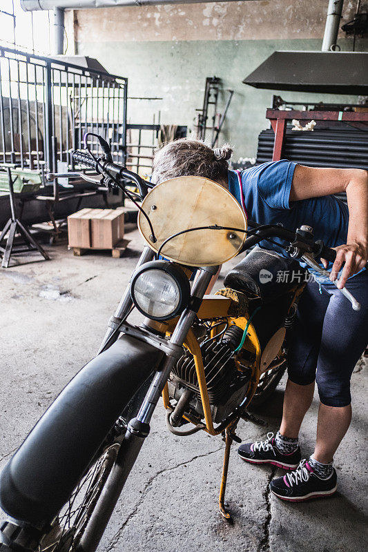 女机械师检查摩托车