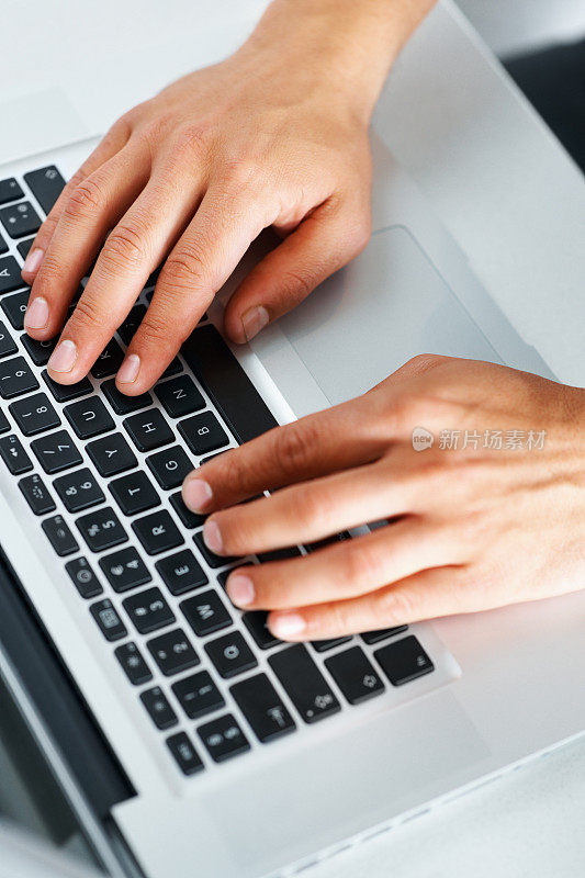 男性用手在笔记本电脑上打字