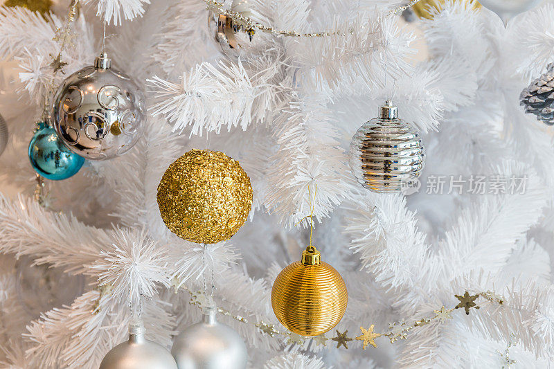 银球和金球花环装饰圣诞和新年节日上的白色圣诞树