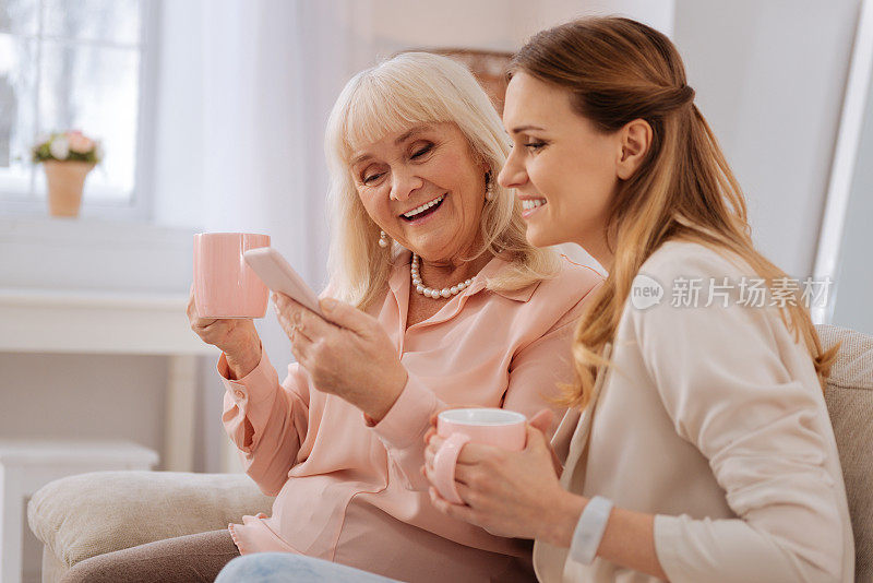 快乐的老年妇女使用她的智能手机