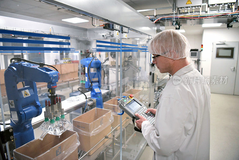 传送带工人操作一个运送胰岛素袋的机器人——医疗保健部门生产药品的现代化工厂