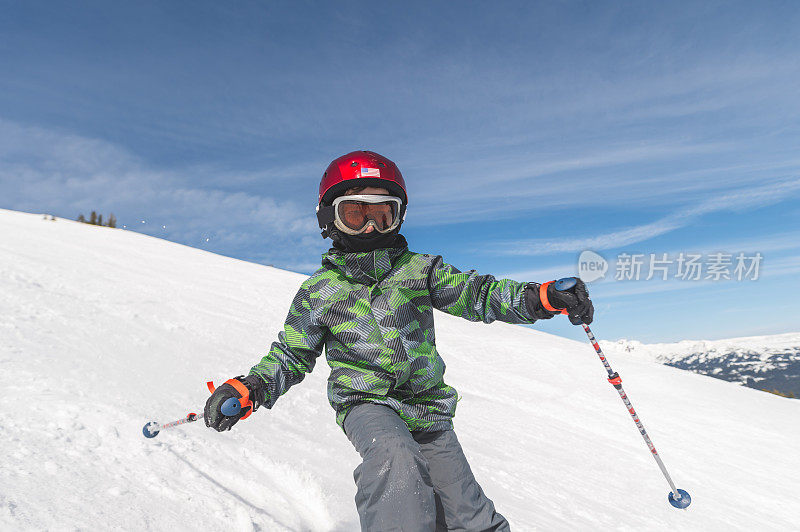 一个小学生从山上滑雪下来