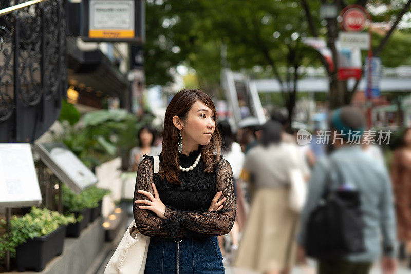 一名女子走在表参道大街上，这是日本最著名的街道之一