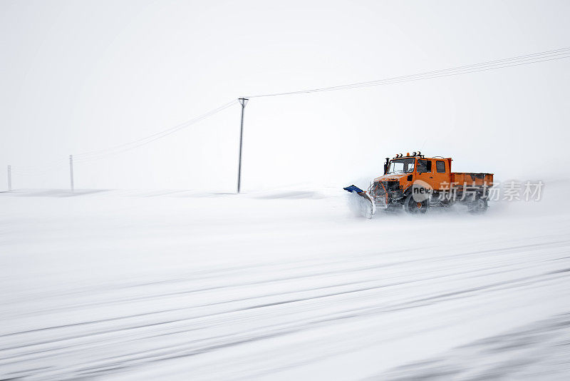 扫雪机清理了被雪覆盖的结冰的道路