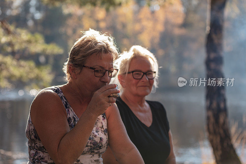 在户外喝咖啡的老妇人