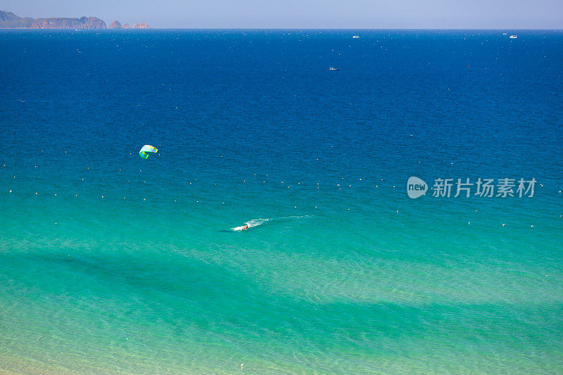 风筝冲浪在热带碧水海滩上从空中鸟瞰拍摄的照片