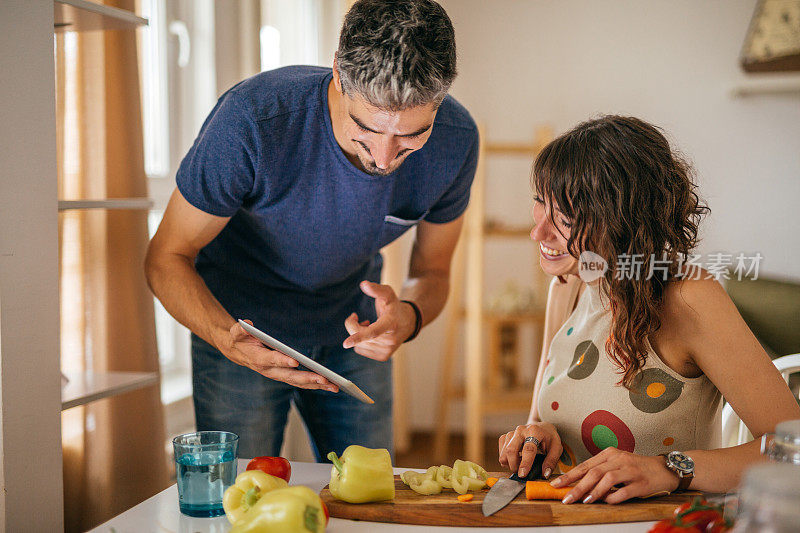 一对年轻的素食夫妇正在厨房里准备饭菜