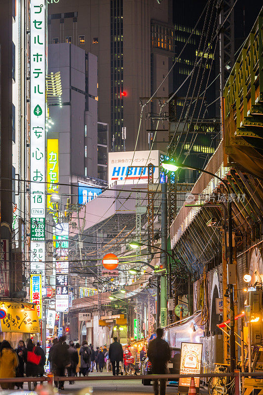 东京高峰时段的通勤者在日本新桥的街道上霓虹闪烁