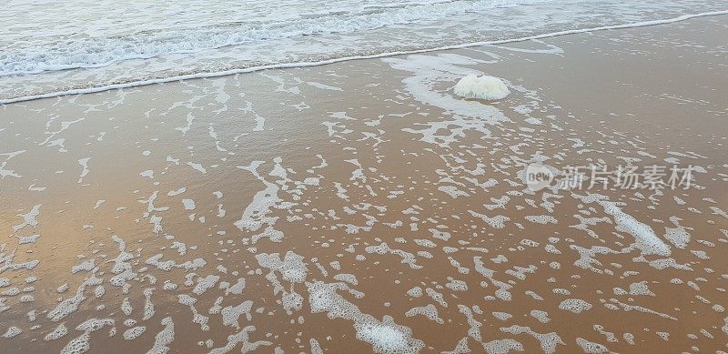泡沫状的白色海浪拍打着海滩