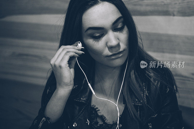 可爱的女孩戴着耳机听音乐