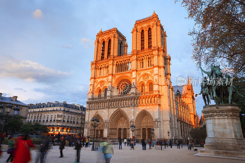 日落时分，巴黎圣母院大教堂和游客们在一起
