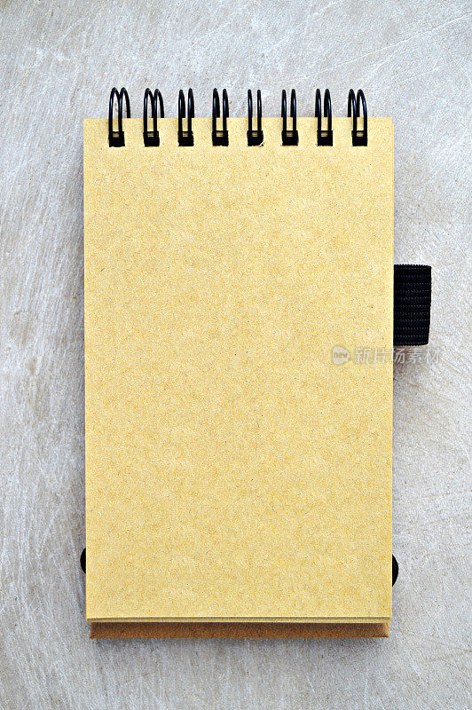 纯空白的黄色米黄色页螺旋装订打开垂直记事本在一个木制的米黄色邋遢复古垂直背景。