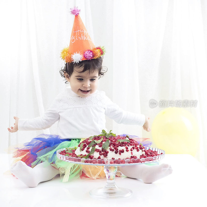 漂亮的小女孩在一周岁生日派对上拿着气球