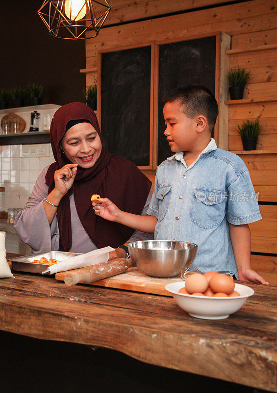 一位马来族穆斯林母亲和她的孩子为开斋节烘培
