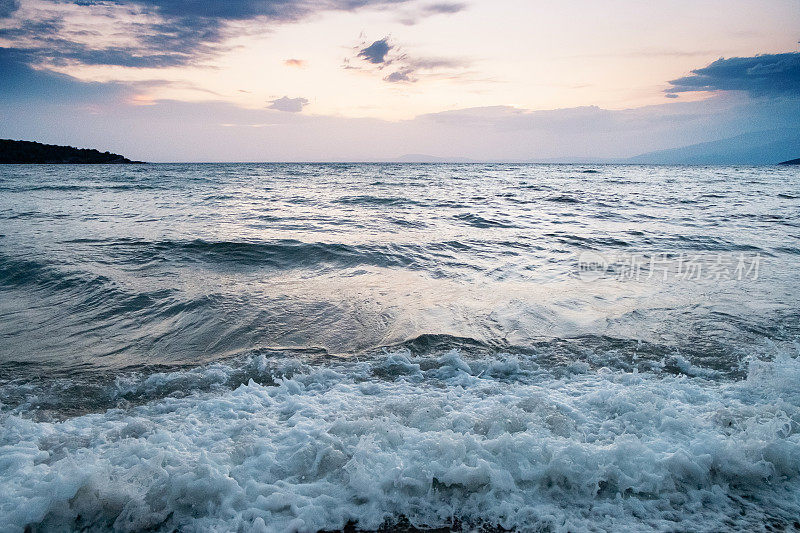 拂晓时海浪在海岸线上激起泡沫