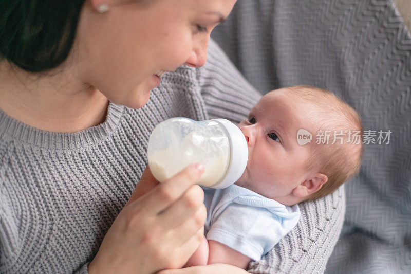 一位母亲用奶瓶喂她刚出生的婴儿