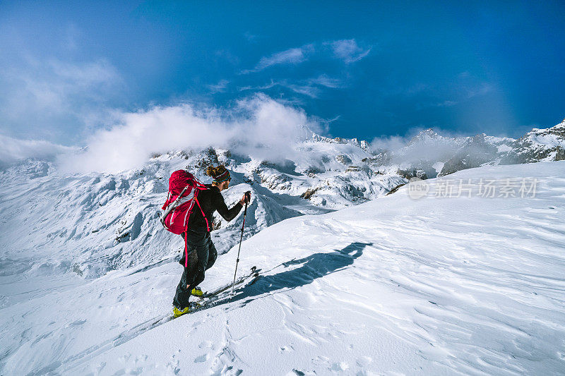 滑雪登山运动员攀登积雪的山脊线