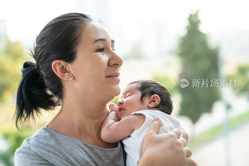 新生儿女婴在母亲肩上的肖像