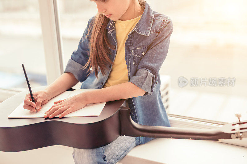 农家女孩在吉他上做笔记