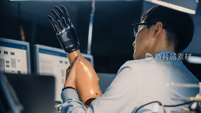 一个未来的假体机器人手臂被专业的日本开发工程师测试在一个高科技研究实验室与现代计算机设备的近距离。