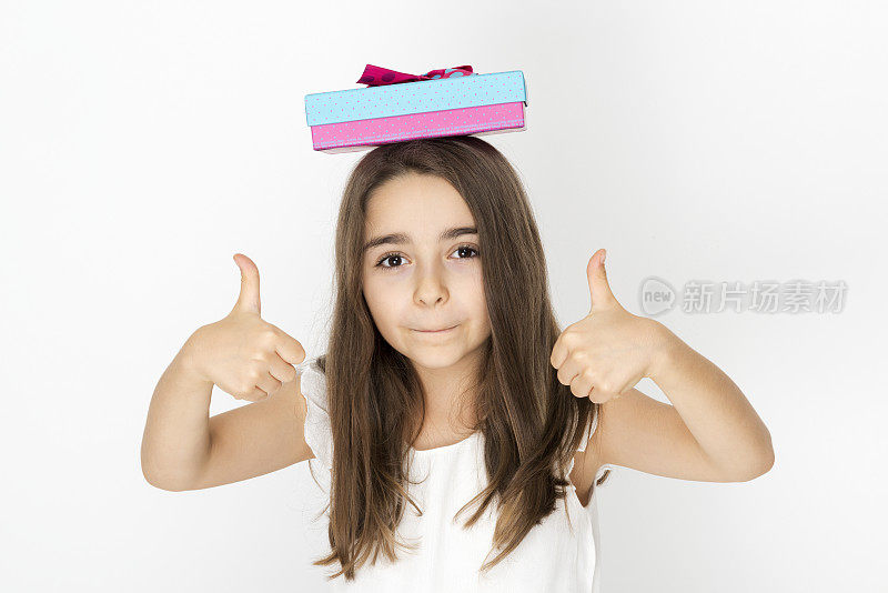 一个白种女孩把礼盒举过头顶表示快乐。