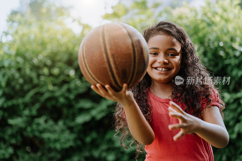 小女孩在院子里玩篮球