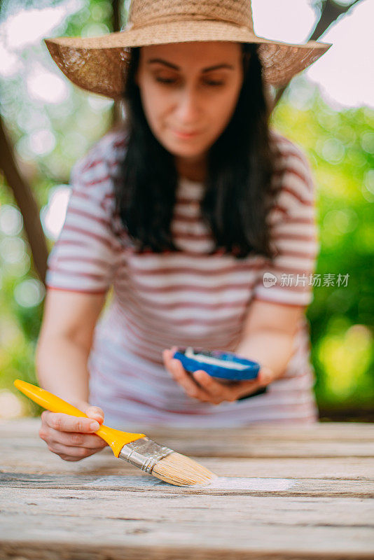 画木桌的女人。在花园里DIY