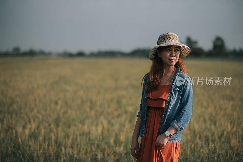 肖像亚洲微笑女性与草帽花闲暇时间在稻田