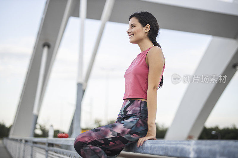 快乐的运动女人在户外慢跑后休息