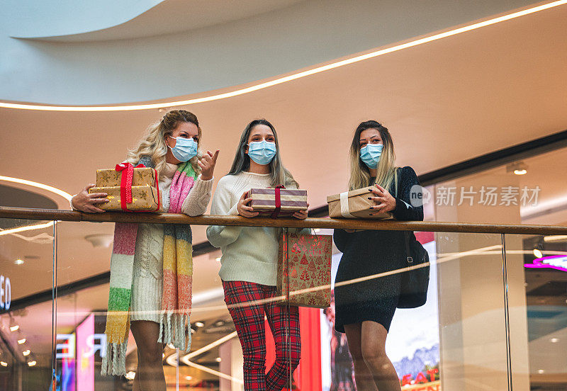 2019冠状病毒病大流行期间，一家人在商场享受圣诞购物。他们戴着防护口罩，以防止冠状病毒感染。