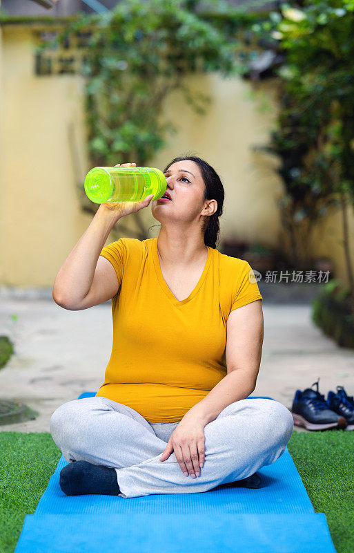 女人在做晨练和瑜伽的时候喝水。