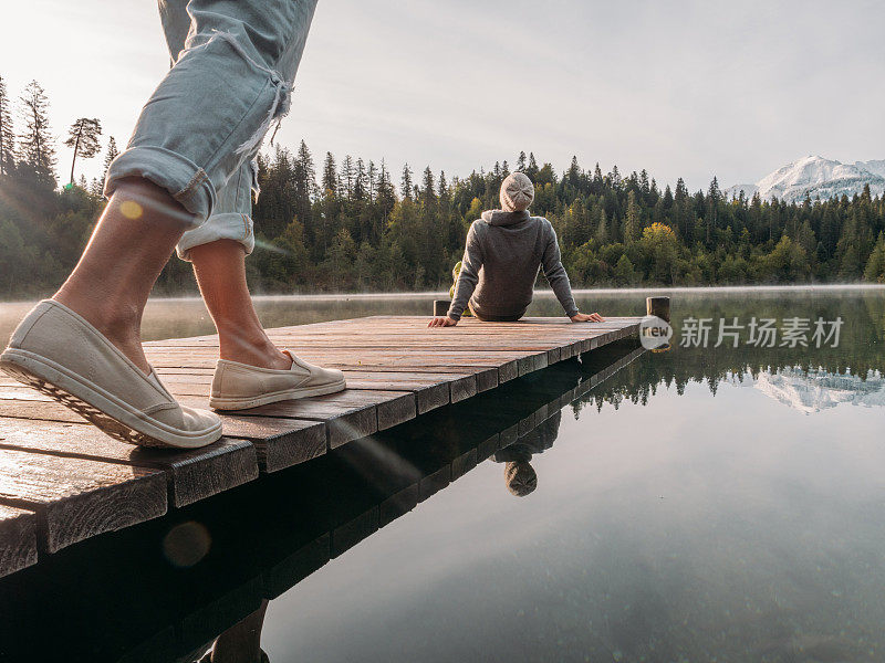 一对夫妇在早晨沿着木码头散步