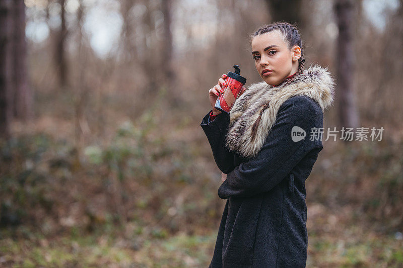 一个年轻漂亮的女人拿着热水瓶的肖像