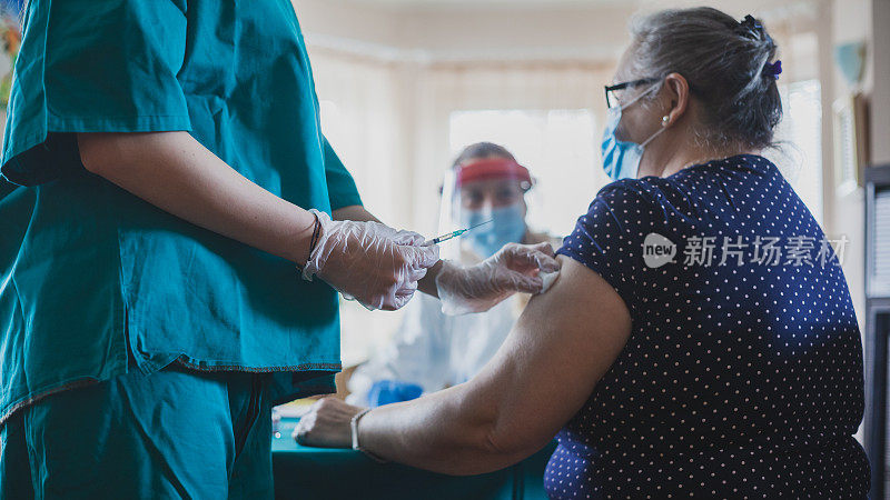 护士在家给老年妇女接种疫苗