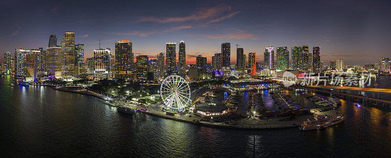 布里克尔市的金融中心，灯火通明的摩天大楼。Skyviews迈阿密观景轮在海湾市场与比斯坎湾的水和美国城市景观在夜晚的倒影