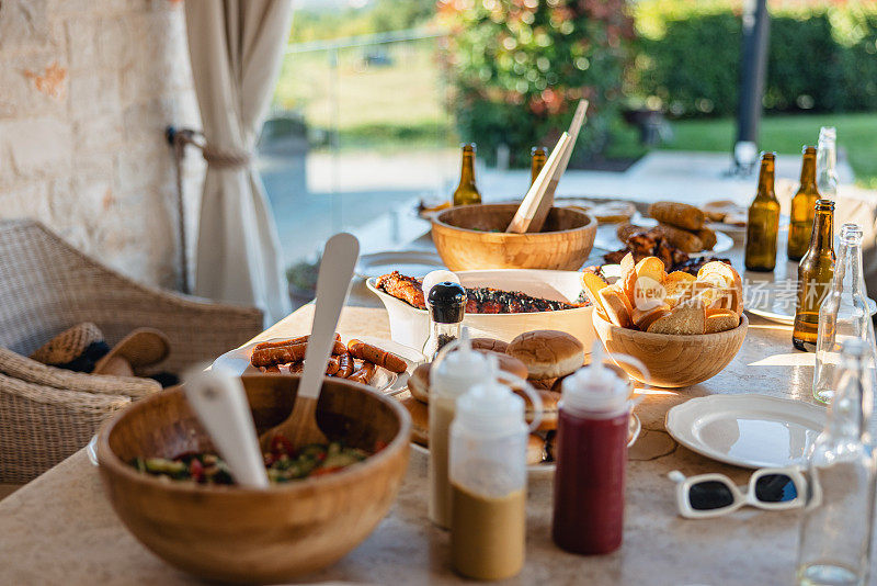 野炊桌设置与盘子，碗和美味的烧烤食物